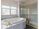 Bathroom with a large soaking tub, shower, and a large window for natural lighting at 116 Willowleaf Dr, Littleton, CO 80127