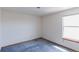 Bedroom features a large window, neutral walls, and blue carpeting at 116 Willowleaf Dr, Littleton, CO 80127