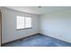 Bedroom features a large window, neutral walls, and blue carpeting at 116 Willowleaf Dr, Littleton, CO 80127