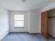 Bedroom features a large window, neutral walls, blue carpeting, and closet at 116 Willowleaf Dr, Littleton, CO 80127
