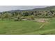 Scenic view of the community with lush green space, natural pond, walking path, and mountain backdrop at 116 Willowleaf Dr, Littleton, CO 80127