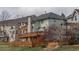 Exterior view of a multi-story home featuring a deck, fenced yard, and mature trees at 116 Willowleaf Dr, Littleton, CO 80127
