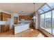 Bright kitchen with light wood cabinets, island, and large windows with mountain views at 116 Willowleaf Dr, Littleton, CO 80127