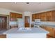 Traditional kitchen showcasing wood cabinetry, white appliances, and a center island with sink at 116 Willowleaf Dr, Littleton, CO 80127