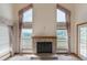 Living room with a brick fireplace, large windows, and scenic views of the outside at 116 Willowleaf Dr, Littleton, CO 80127