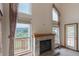 Living room featuring a brick fireplace, tall windows, and outdoor views at 116 Willowleaf Dr, Littleton, CO 80127