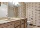 Bathroom featuring a dual sink vanity, floral wallpaper and toilet at 5138 S Sedalia Ct, Centennial, CO 80015
