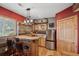 Home bar area includes bar seating, stainless steel refrigerator and wooden cabinets at 11594 Yellow Daisy Dr, Parker, CO 80134