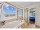 Modern bathroom with a glass-enclosed shower, soaking tub, and large windows with a view at 11594 Yellow Daisy Dr, Parker, CO 80134