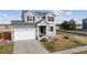 Charming two-story home featuring a well-kept lawn and a two-car garage, freshly painted in neutral gray with blue shutters at 11594 Yellow Daisy Dr, Parker, CO 80134