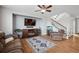 Cozy living room featuring hardwood floors, a comfortable sofa, a large television, and a staircase to upper floors at 11594 Yellow Daisy Dr, Parker, CO 80134