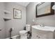 Powder room has gray walls, white vanity, and framed mirror at 11594 Yellow Daisy Dr, Parker, CO 80134