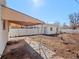 Backyard featuring a detached garage, patio, and a white fence under a clear blue sky at 3245 S Elati St, Englewood, CO 80110