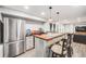 Basement bar with stainless steel refrigerator, sink, wooden countertop and pendant lights at 22428 Quail Run Ln, Parker, CO 80138