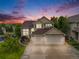 Beautiful two-story home with a three-car garage and well-manicured landscaping at sunset at 22428 Quail Run Ln, Parker, CO 80138