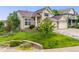 Charming two-story home with manicured lawn, garden beds, and a three-car garage at 22428 Quail Run Ln, Parker, CO 80138