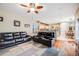 Open-concept living area with access to kitchen and dining space. Leather furniture and ceiling fan at 22428 Quail Run Ln, Parker, CO 80138