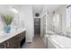 Bright bathroom featuring a double vanity, soaking tub, and glass-enclosed shower at 14100 Blue Wing Ln, Parker, CO 80134