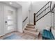 Bright foyer with wood floors, stairs with wood and iron railing, and a modern front door at 14100 Blue Wing Ln, Parker, CO 80134