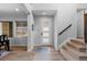 Bright foyer with wood floors, stairs with wood railing, and a modern front door at 14100 Blue Wing Ln, Parker, CO 80134