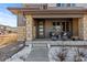 Inviting front porch with stylish seating and stone pillars, leading to a modern front door at 14100 Blue Wing Ln, Parker, CO 80134