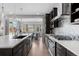 Gourmet kitchen with island, stainless steel range hood, cooktop, built-in ovens and views to an outside patio at 14100 Blue Wing Ln, Parker, CO 80134
