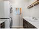 Efficient laundry room with stacked washer and dryer, ample counter space, and storage shelves at 14100 Blue Wing Ln, Parker, CO 80134