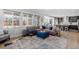 Open-concept living room with a comfortable sectional, large windows, and views into the kitchen at 14100 Blue Wing Ln, Parker, CO 80134