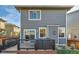 Backyard view displays outdoor seating on a wooden deck, and siding of house at 6893 Decatur St, Denver, CO 80221