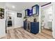 Finished basement bar with custom cabinets, brick backsplash, wine cooler and wood-look flooring at 6893 Decatur St, Denver, CO 80221