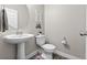 Well-lit powder room with a pedestal sink, modern fixtures, and stylish decor at 6893 Decatur St, Denver, CO 80221