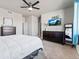 Spacious bedroom with a large window, carpet, ceiling fan, dressers, TV and a mirror, creating a comfortable ambiance at 6893 Decatur St, Denver, CO 80221