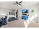 Relaxing bonus room with TV, ceiling fan, half wall, carpet, and a blue storage unit, ideal for entertainment at 6893 Decatur St, Denver, CO 80221