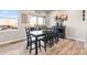 Bright dining room featuring wood floors, a modern table, and natural light from the sliding glass doors at 6893 Decatur St, Denver, CO 80221
