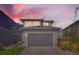 Contemporary home with a gray exterior, large garage door and well maintained lawn at 6893 Decatur St, Denver, CO 80221