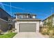 Two-story home featuring a well-manicured lawn and an attached two-car garage at 6893 Decatur St, Denver, CO 80221