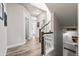 Bright hallway with wood floors and access to the staircase and front door at 6893 Decatur St, Denver, CO 80221