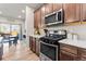 Modern kitchen featuring stainless steel appliances, and wood cabinets, complemented by wood flooring at 6893 Decatur St, Denver, CO 80221