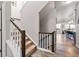 Modern staircase with wooden railings and neutral carpeting, flowing into an open-concept living space at 6893 Decatur St, Denver, CO 80221