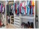 Organized walk-in closet with built-in shelving, hanging rods, drawers, and carpet, maximizing storage and functionality at 6893 Decatur St, Denver, CO 80221