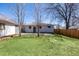 Large backyard with green lawn, a patio area and a detached garage provides ample space for outdoor activities at 7977 Durango St, Denver, CO 80221