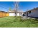 Large backyard with a detached garage, patio, and privacy fence at 7977 Durango St, Denver, CO 80221