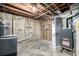 Unfinished basement showcasing exposed ceiling and concrete walls with a doorway to another room at 7977 Durango St, Denver, CO 80221