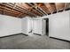 Unfinished basement room with exposed ceiling and new carpet is ready for your custom build-out at 7977 Durango St, Denver, CO 80221