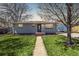 Charming single-story home showcasing a well-manicured lawn, a concrete walkway, and fresh landscaping around the tree at 7977 Durango St, Denver, CO 80221