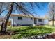 This home boasts a lush green lawn and blooming trees, creating a serene and inviting outdoor space at 7977 Durango St, Denver, CO 80221