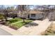 Charming home featuring a well-kept lawn, mature trees, and a long driveway at 7977 Durango St, Denver, CO 80221