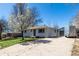 Quaint home with a manicured lawn, complemented by a blossoming tree in the front yard at 7977 Durango St, Denver, CO 80221