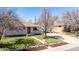 Well-maintained front yard with lush grass, a blooming tree, and a charming walkway to the front door at 7977 Durango St, Denver, CO 80221