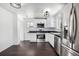 Modern kitchen features stainless steel appliances, white cabinets, and black countertops at 7977 Durango St, Denver, CO 80221